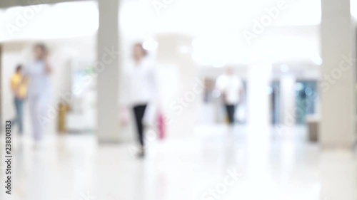 Blurred unidentified patient and medical staff walking in the hospital for background use. Still shot 4K video.
