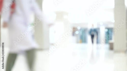 Blurred unidentified patient and medical staff walking in the hospital for background use. Still shot 4K video.