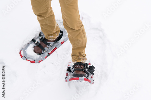 close - up of snowshoes on the man's feet, in brown boots