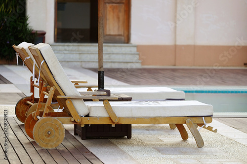 Beautiful wooden chairs with wheel legs at the swimming pool