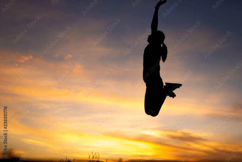 happiness, freedom, motion and people concept - smiling young woman jumping in air sunset background