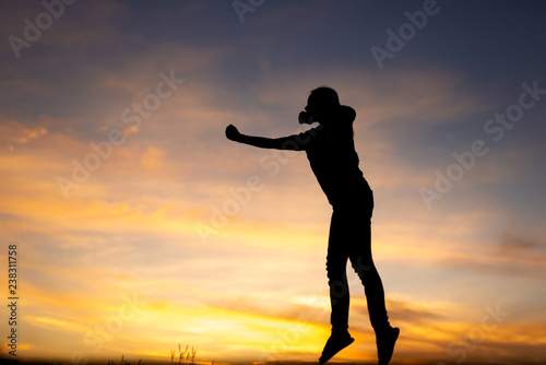 happiness  freedom  motion and people concept - smiling young woman jumping in air sunset background