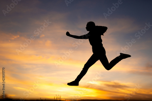 happiness  freedom  motion and people concept - smiling young woman jumping in air sunset background