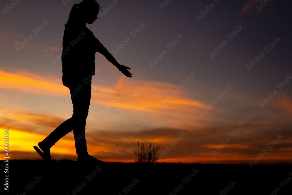 Silhouette of sad and depressed women walking at walkway of park with sunset