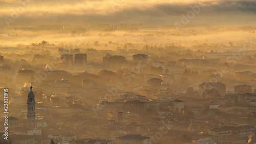 Bergamo, Italy. Amazing landscape of the town covered by the fog arising from the plain in fall season