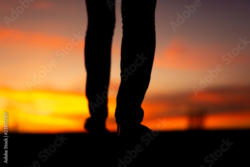 Silhouette of sad and depressed women walking at walkway of park with sunset