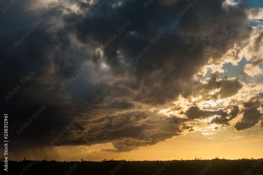 Imposing storm clouds gathering over the Northern Parts of Friesland, the Netherlads, during sunset