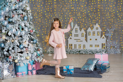 Cute girl near the Christmas tree enjoy miracle winter time. Christmas concept. Belief in miracles.