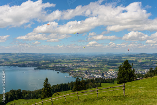 Panoramic view on paragliders flying around Zugerberg hill over the city of Zug in Central Switzerland photo