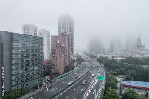 Aerial view of buildings and highway in the morning fog