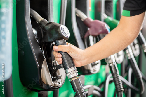 Pumping equipment gas at gas station. Close up of a hand holding fuel nozzle