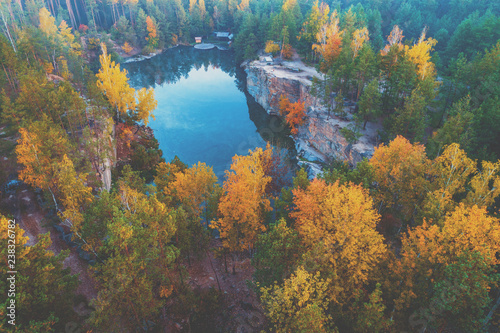 Aerial view of the beautiful lake in the autumn forest. Granite lakeshore