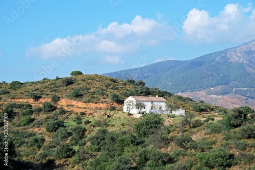 View across countryside towards the Sierra de Mijas mountains with a traditional Spanish finca in the foreground near Fuengirola, Spain. © arenaphotouk