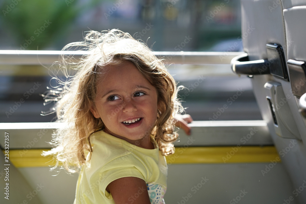 Happy blonde little girl in the tourist bus Happy blonde little girl in the tourist bus