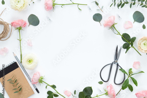 Flat lay of Beautiful green branches and pink white flowers frame on pastel background. Top view. Lifestyle spting composition. photo