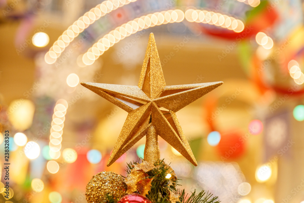 A Christmas decorative - star on the top of A Christmas tree with a beautiful bokeh background