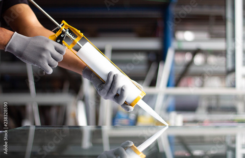 Men's hand uses silicone adhesive with adhesive to connect the mirror with aluminum.