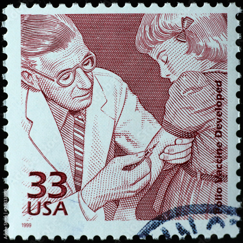 Doctor injecting polio vaccine on american postage stamp photo