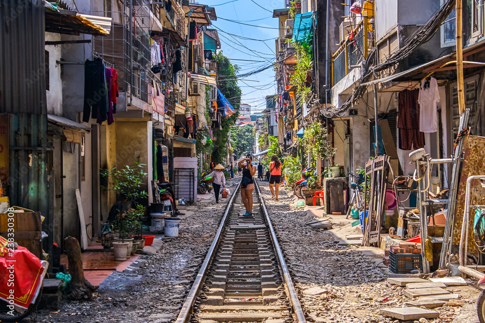 Woman is making a picture of Hanoi city railway Perspective view running along narrow street with houses in Vietnam