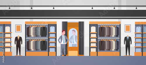 businessman trying on new business suit elegant man looking at mirror fashion shop male clothes market modern shopping mall interior flat horizontal