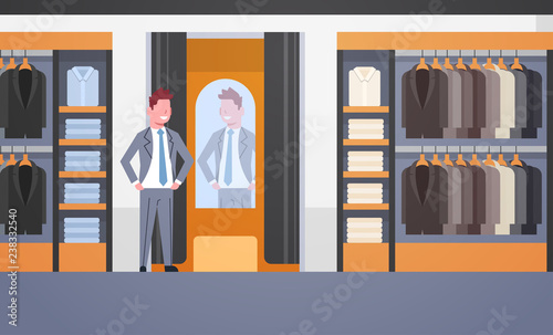 businessman trying on new business suit elegant man looking at mirror fashion shop male clothes market modern shopping mall interior flat horizontal