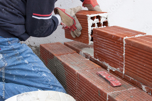 Building double wall of bricks with space in between for insulation with polystyrene foam, energy efficient construction