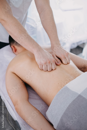 Sports massage. Therapist working with shoulders