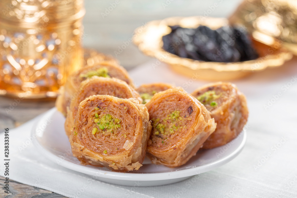 Traditional arabic dessert baklava with cashew, walnuts and cardamom with an eucalyptus branch on a wooden table