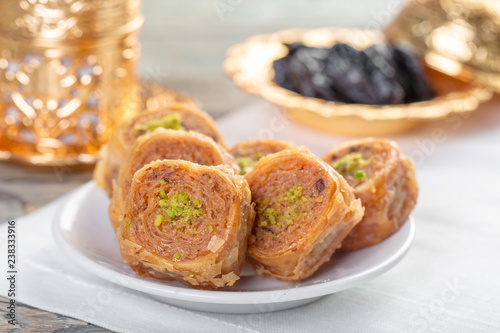 Traditional arabic dessert baklava with cashew, walnuts and cardamom with an eucalyptus branch on a wooden table