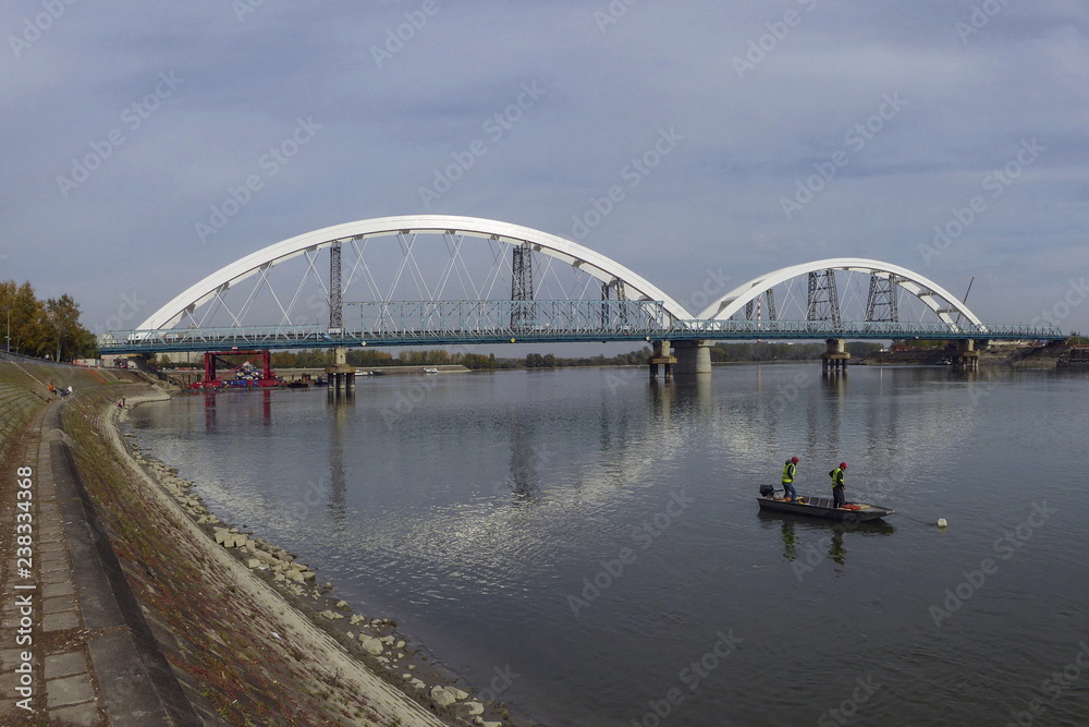New bridge over Danube in Novi Sad, two fishermenin the boat on the river