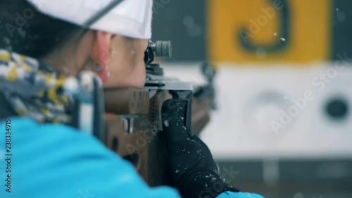 Backside view of a sportswoman shooting on a biathlon stadium photo