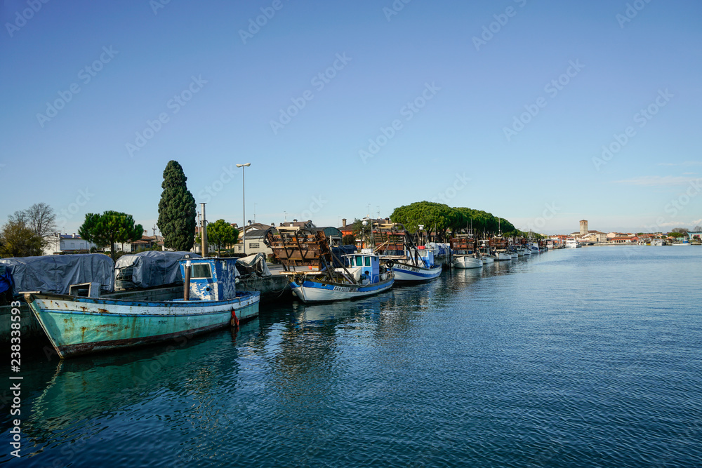 Some fishing boats moored on the pier of the port of Marano Lagunare, Friuli Venezia Giulia Region, Italy