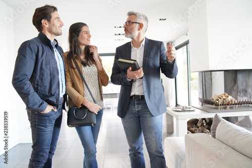   Couple with real-estate agent visiting modern house photo