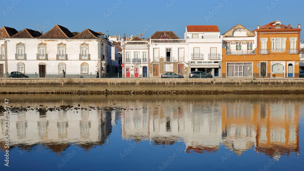 Historical buildings located on Jacques Pessoa street and reflected in the river Rio Gilao, Tavira, Algarve, Portugal