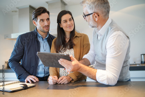  Kitchen salesman going through ideas with potential buyer couple