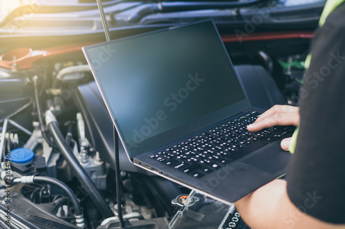 Close up engineer  mechanic using electrnoic diagnostic equipment to tune a car. photo