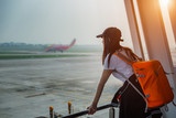 woman traveler passenger delay and lost of flight looking at the aircraft run away in runway with disappointed and upset on missed the flight