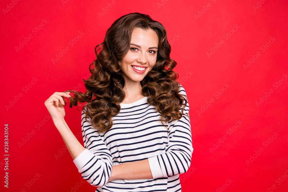 Close up portrait of cute perfect maquillage she her girl after visiting hairdresser with one curl in hand delighted with result white striped pullover isolated on red vivid background Close up portrait of cute perfect maquillage she her girl after visiting hairdresser with one curl in hand delighted with result white striped pullover isolated on red vivid background