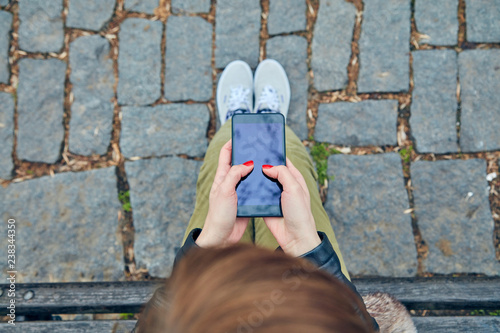 Woman sitting on a bench and using smartphone. photo