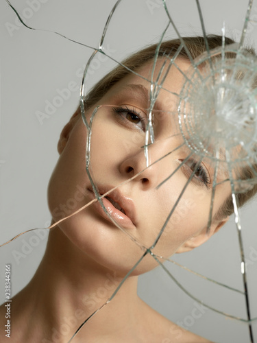 beautiful blonde woman reflected in a broken mirror