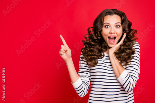 Close up photo of attractive pretty beautiful she her lady finger up to empty space wondered if to buy buyer shirt ask advise wearing white striped pullover isolated on red vivid background photo