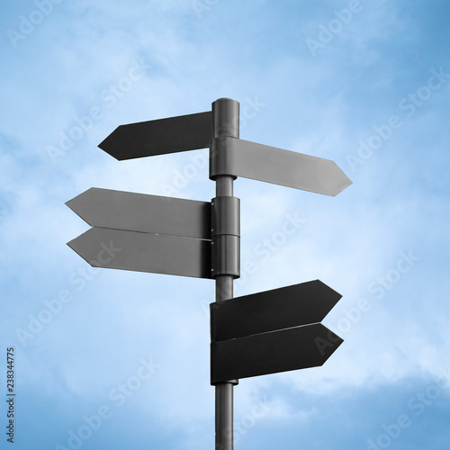 Empty dark metal signpost isolated on sky background