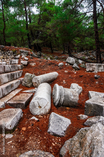 Old ruin of Cadianda (Kadyanda) Ancient City view near Uzumlu village in Fethiye, Mugla, Turkey. Roman settlement at BC 5th century. An old city from inside mystic red forest. Lycian way. photo