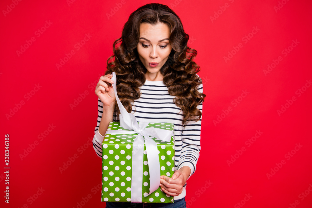 Portrait of nice girlish childish winsome attractive cheerful wavy-haired lady wearing striped pullover holding in hand opening large green box guessing isolated on bright vivid shine red background Portrait of nice girlish childish winsome attractive cheerful wavy-haired lady wearing striped pullover holding in hand opening large green box guessing isolated on bright vivid shine red background