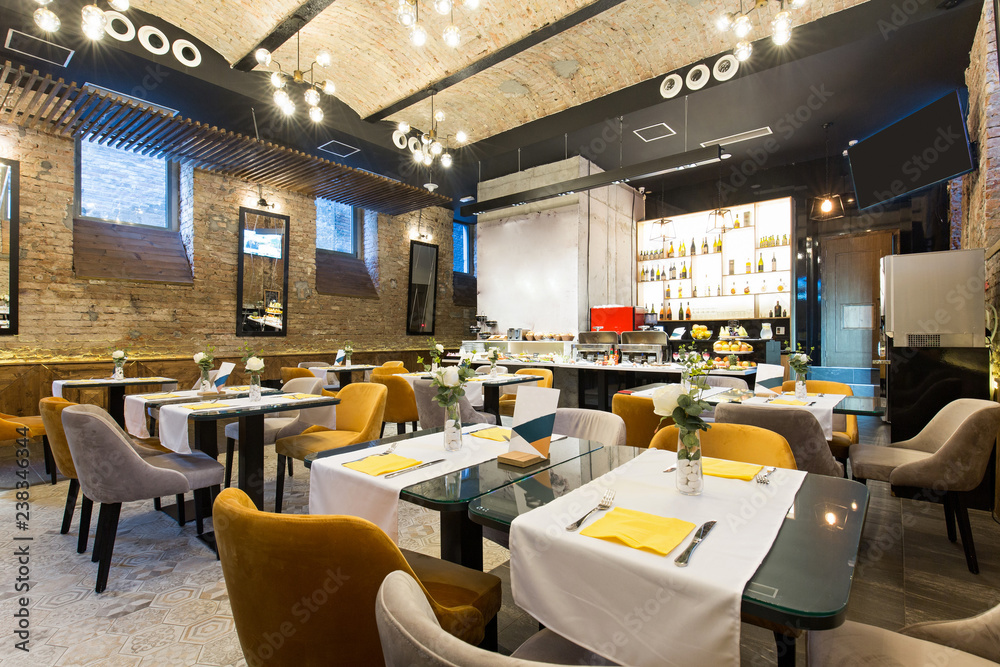 Interior of a modern hotel restaurant with brick wall