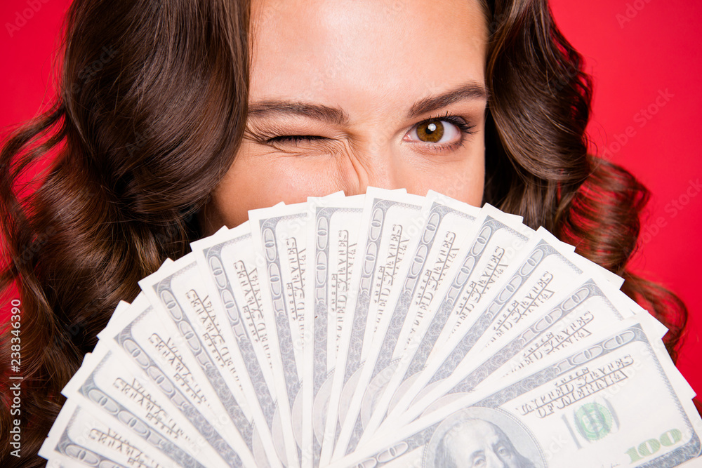 Close-up cropped portrait of rich funky attractive cheerful positive wavy-haired lady holding in hands hiding behind fan of hundreds usd dollars isolated over bright vivid shine red background Close-up cropped portrait of rich funky attractive cheerful positive wavy-haired lady holding in hands hiding behind fan of hundreds usd dollars isolated over bright vivid shine red background