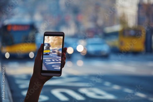 Woman using cellphone and crossing the street.