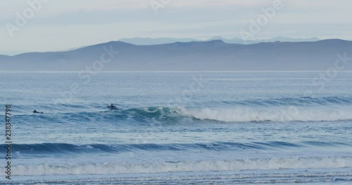 Slow motion of surfers in Morro Bay, Claifornia photo