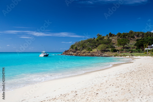Fototapeta Naklejka Na Ścianę i Meble -  Tropical beach at Antigua island in Caribbean with white sand, turquoise ocean water and blue sky