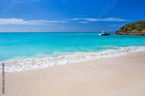 Tropical beach at Antigua island in Caribbean with white sand  turquoise ocean water and blue sky